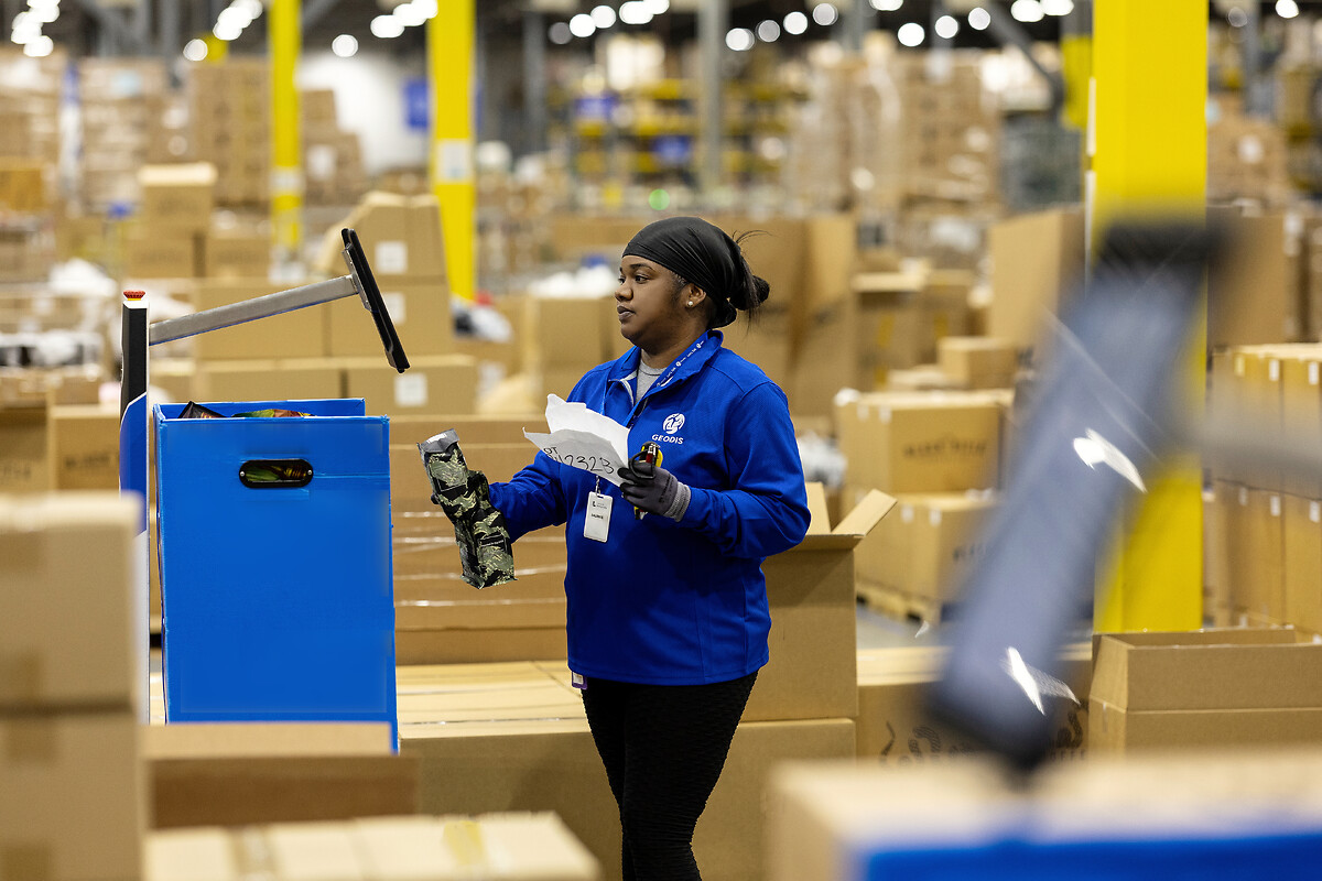 E-commerce B2C : La collaboratrice GEODIS scan le produit, le robot Locus confirme la référence et indique son emplacement de stockage   