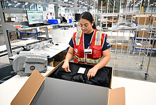 Une employer GEODIS mettant une veste dans une box