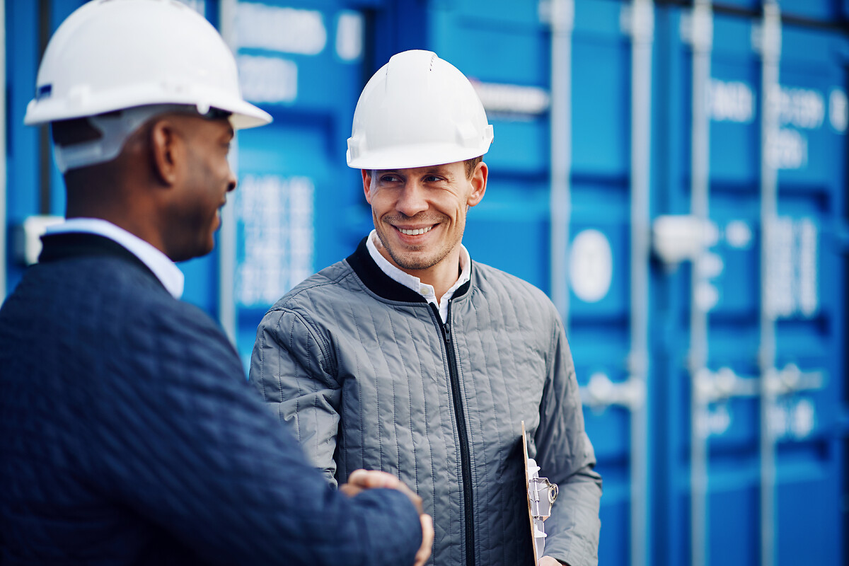 Men shaking hands for logistics partnership in harbour