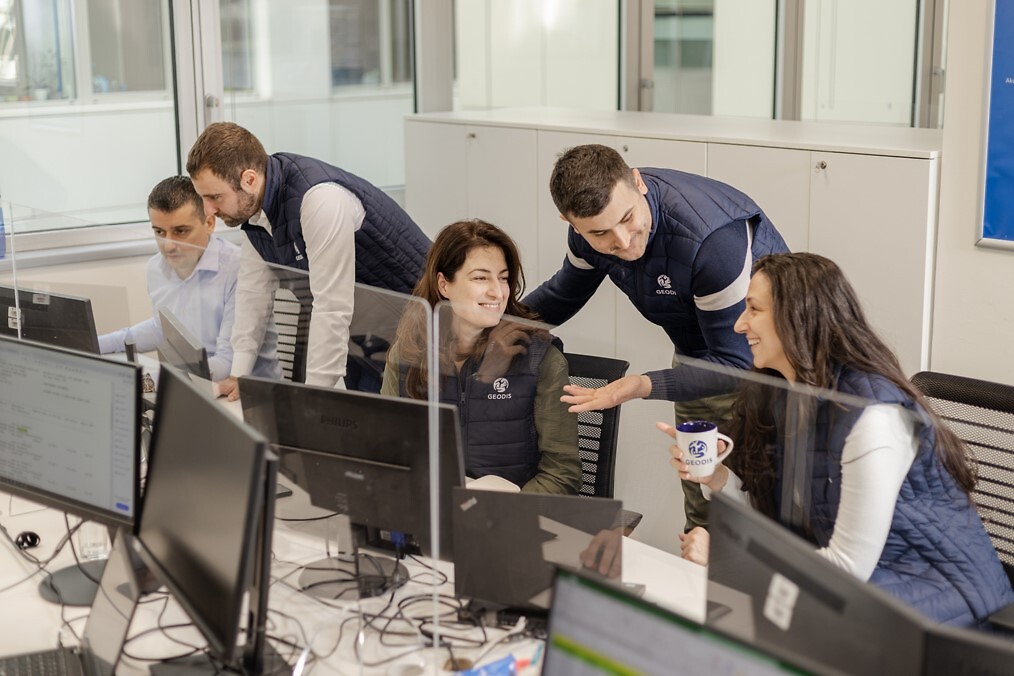 Five peoples in an office speaking with GEODIS hoodies