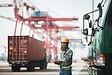 Person directing trucks and containers