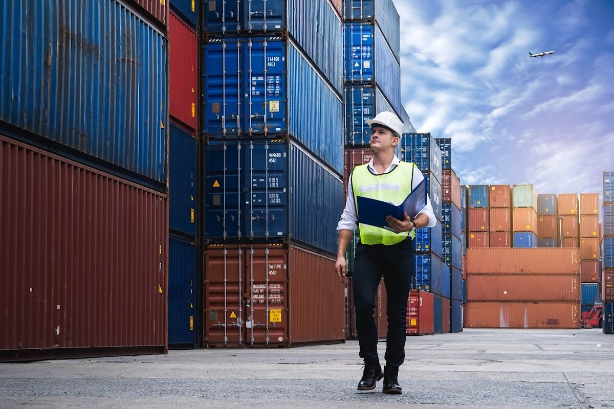 Person with folder looking at containers in a port
