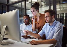 Three people looking at a computer screen