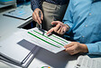 using computer together in office, successful business people working together in a co-working office, two business professionals working on a tech project, business colleagues talking to each other,