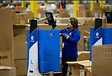 A woman using a Locus Robotics device to pick items at a warehouse