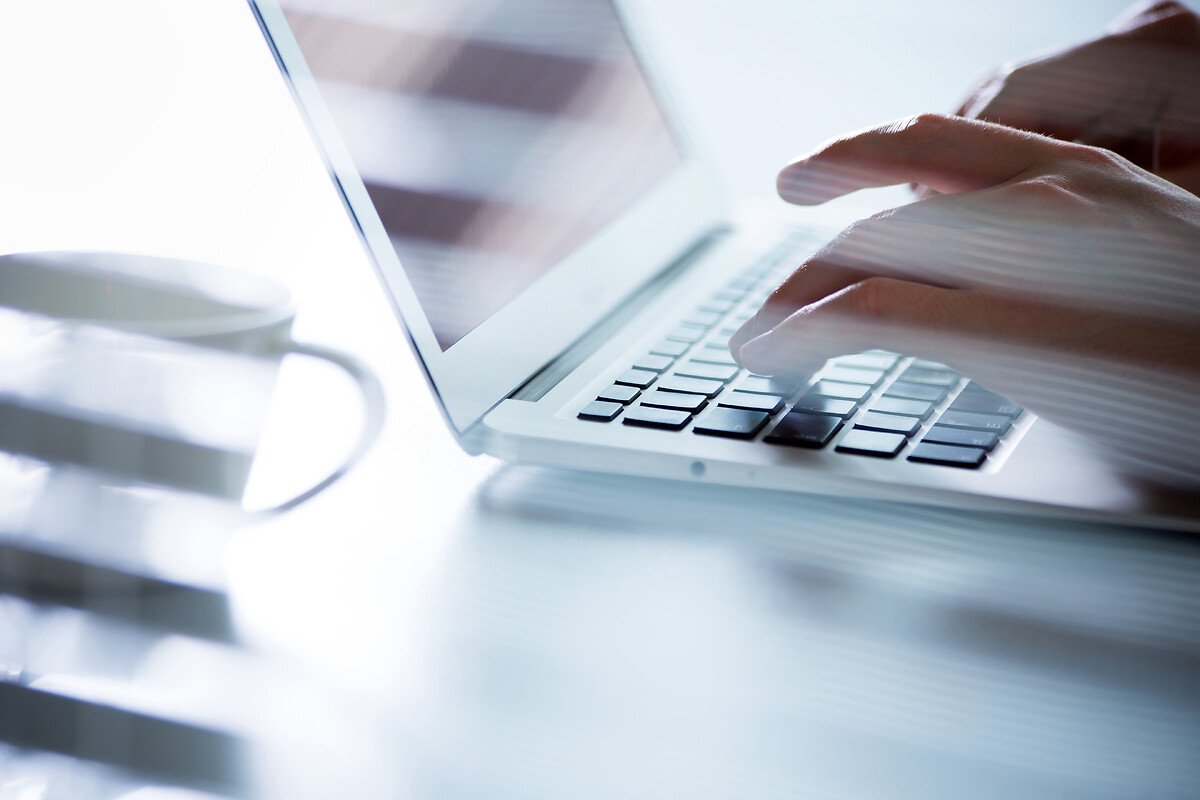 des mains qui tapent sur le clavier d'un pc