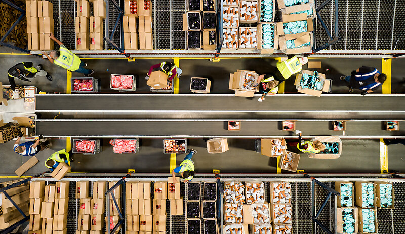 PICT077526-Teammates-forming-an-assembly-line-at-a-conveyor-system-so-they-can-pack-a-subscription-box-EDELSON-Josh