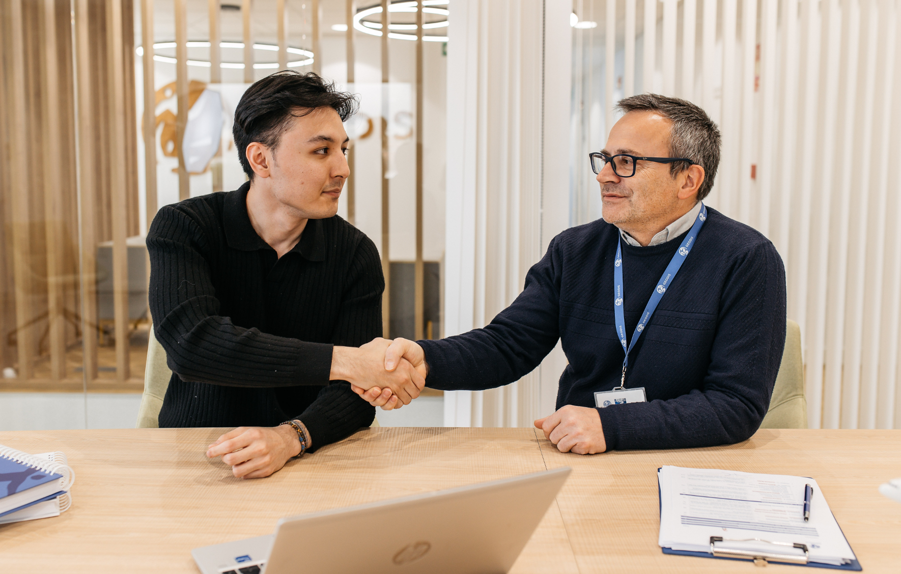 Two-men-working-in-transportation-industry-shaking-hands-in-front-of-a-signed-contract