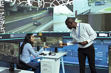 African american supervisor gives insight to indian operator in control center