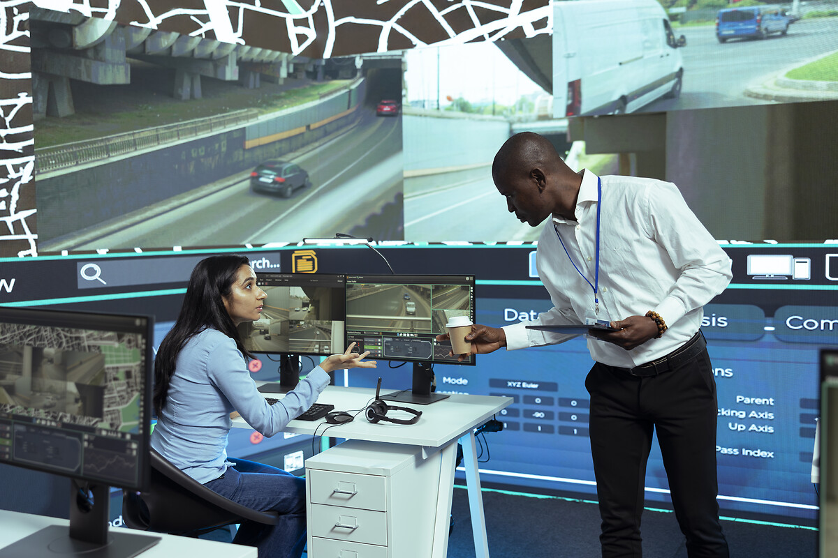 African american supervisor gives insight to indian operator in control center