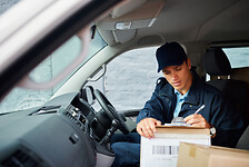 Cropped shot of a handsome young delivery man using a clipboard