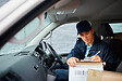Cropped shot of a handsome young delivery man using a clipboard