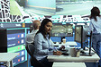 Indian woman employee locating delivery truck drivers via satellite map