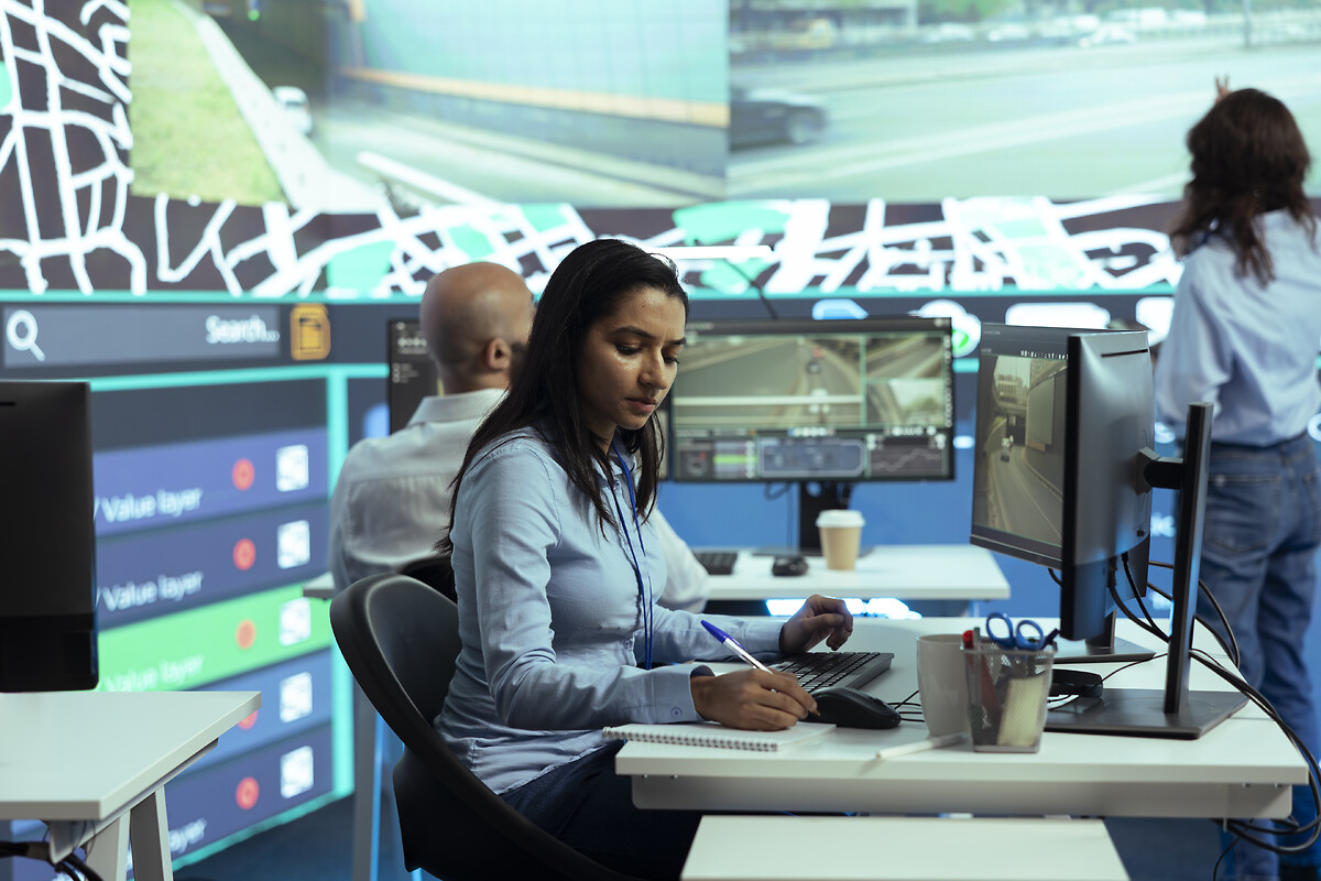Indian woman employee locating delivery truck drivers via satellite map
