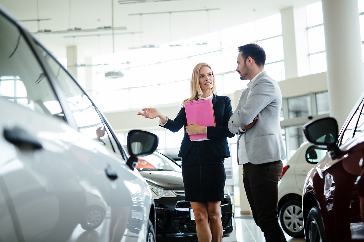 Femme qui vend une voiture à un client