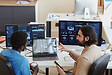 Young confident IT engineer explaining graphic data to his colleague