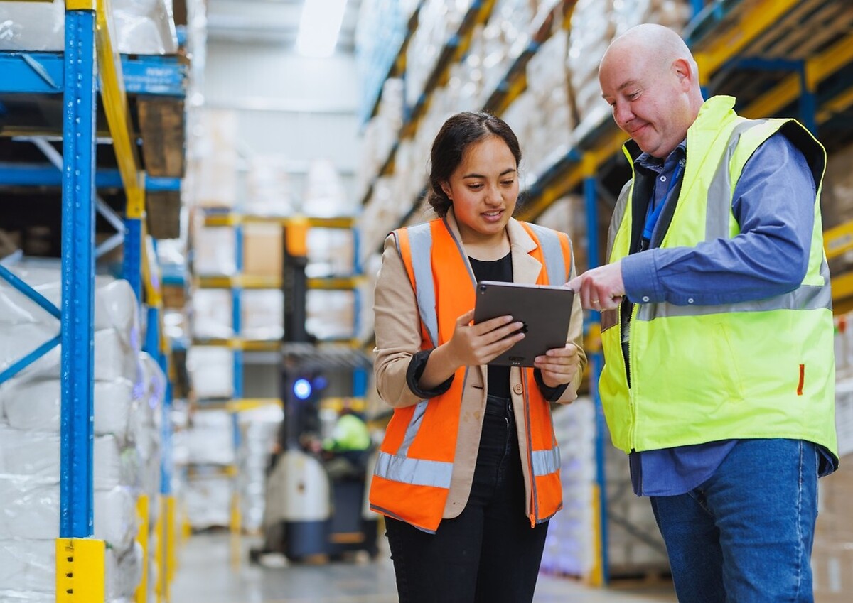woman and man employees discussing with a tablet in a logistic Freight Forwarding warehouse.jpg